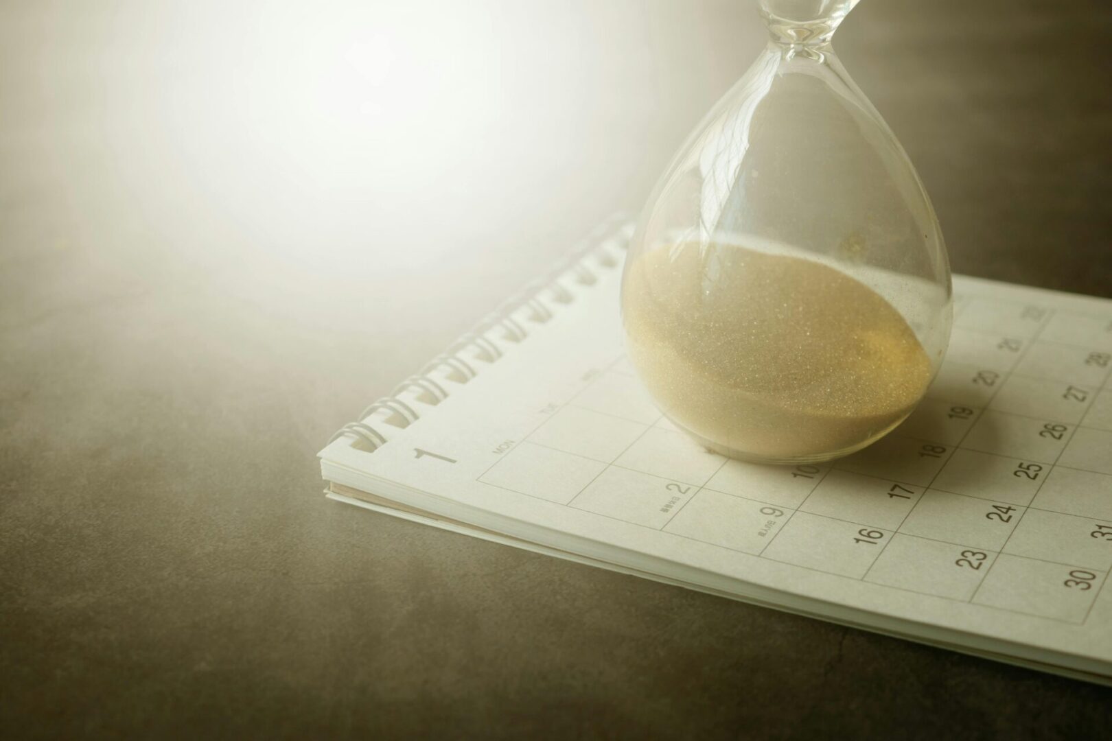 A glass of water sitting on top of a calendar.