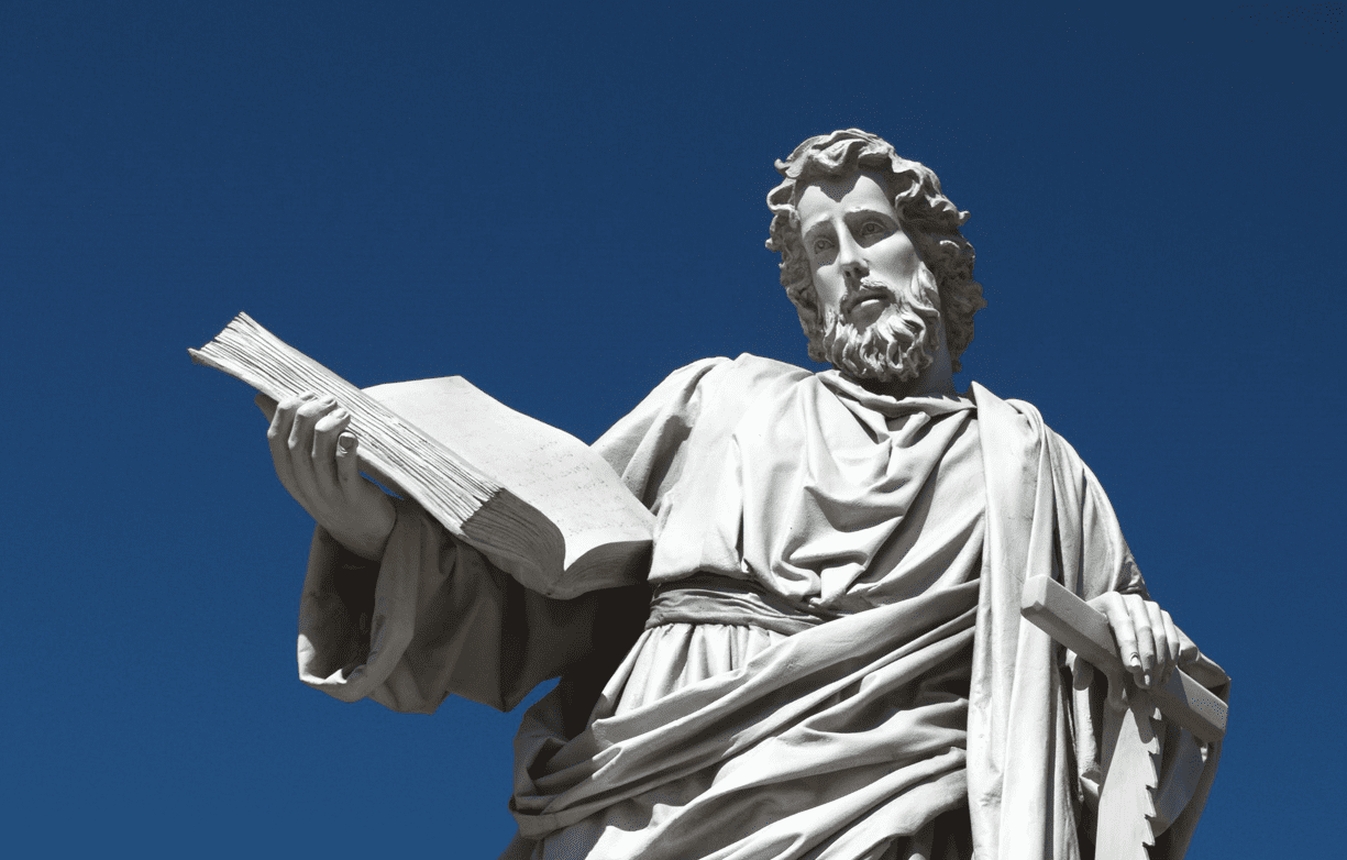 A statue of jesus holding the book in his hands.