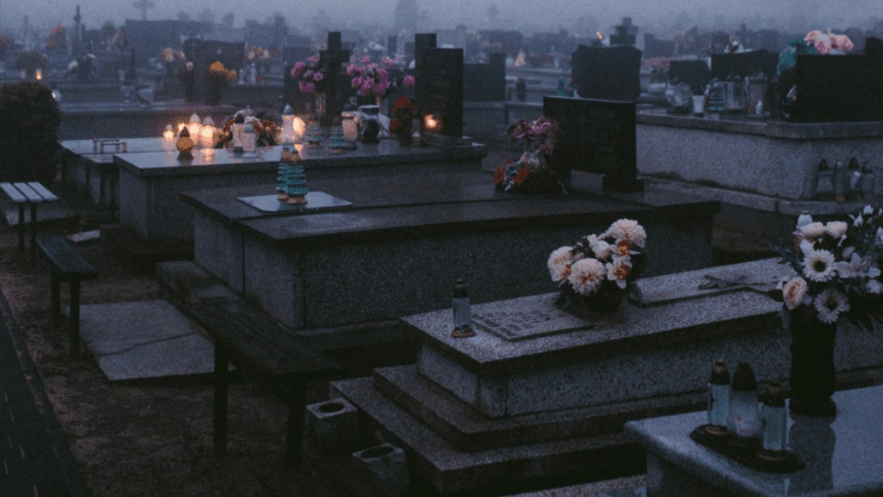 A graveyard at night with above ground tombs