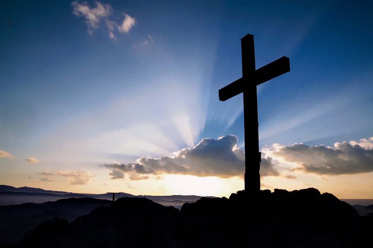 A cross is shown on top of a hill.