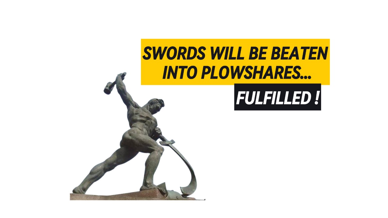 Statue of a man swinging a hammer and beating a sword into a plowshare.