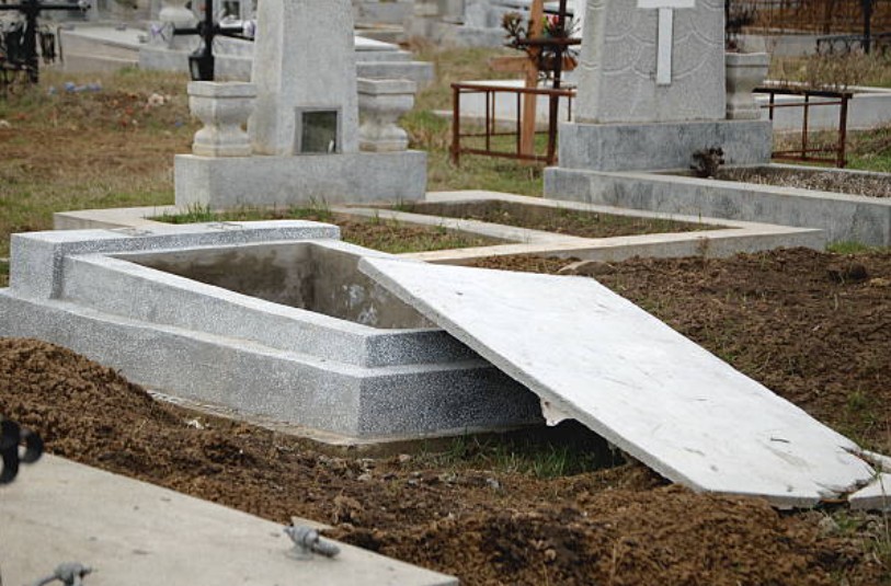 An stone grave casket with an open cover.