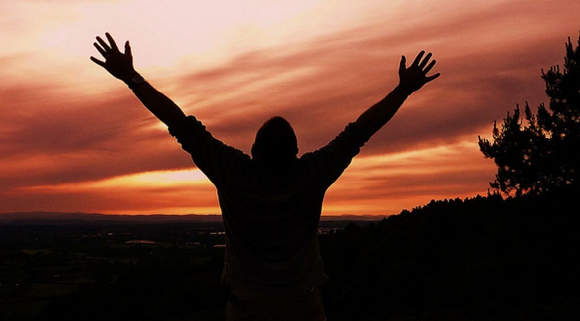 A man with arms raised in victory and freedom