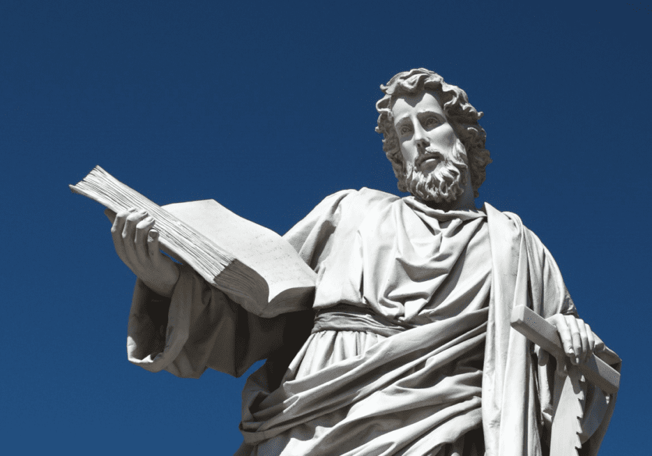 A statue of jesus holding the book in his hands.