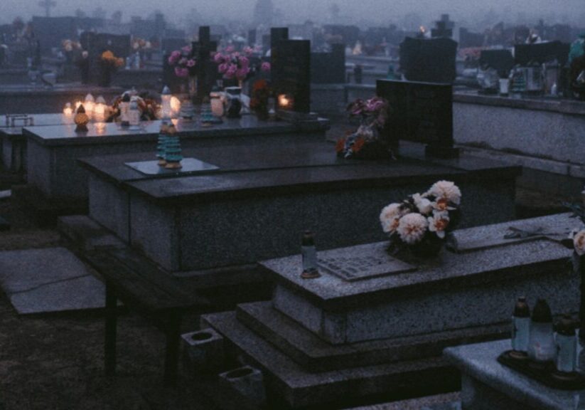 A graveyard at night with above ground tombs