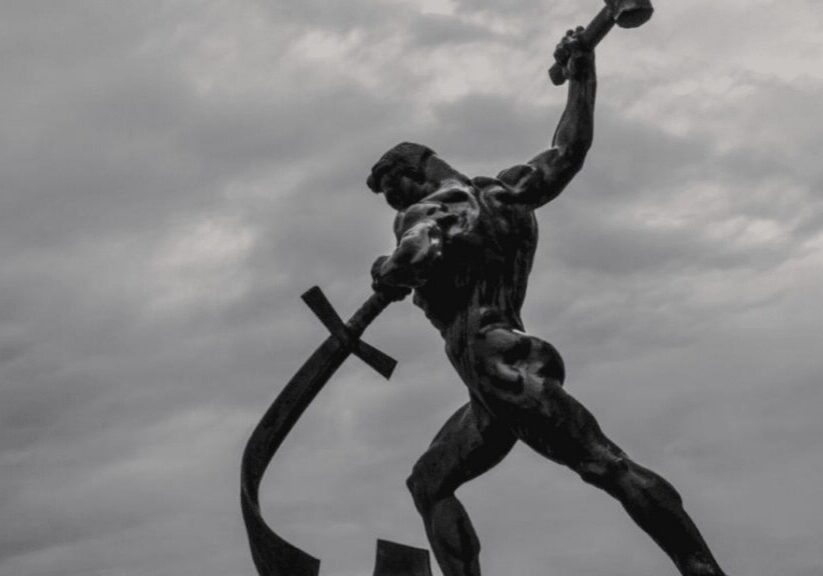 A statue of a man beating a sword into a plowshare