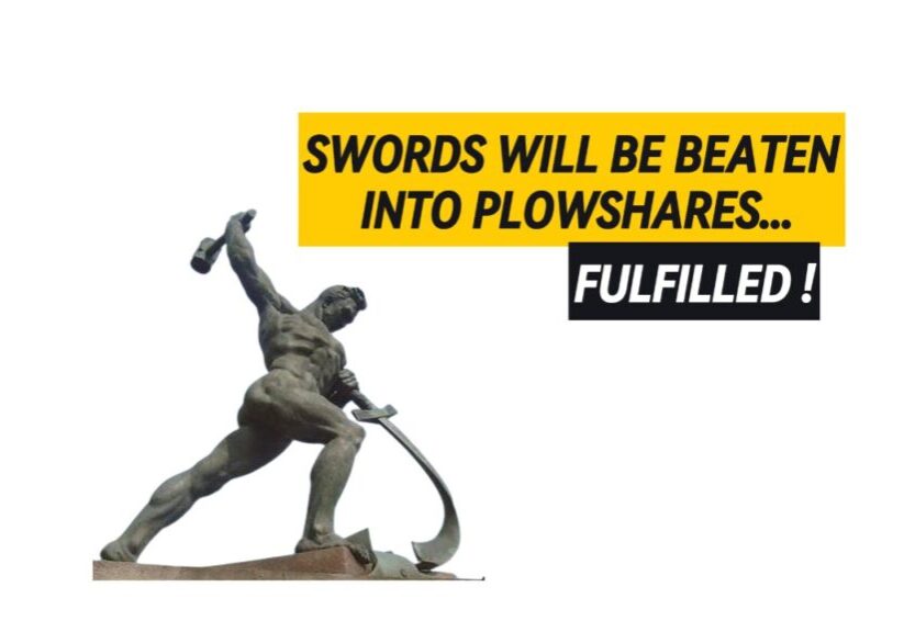 Statue of a man swinging a hammer and beating a sword into a plowshare.