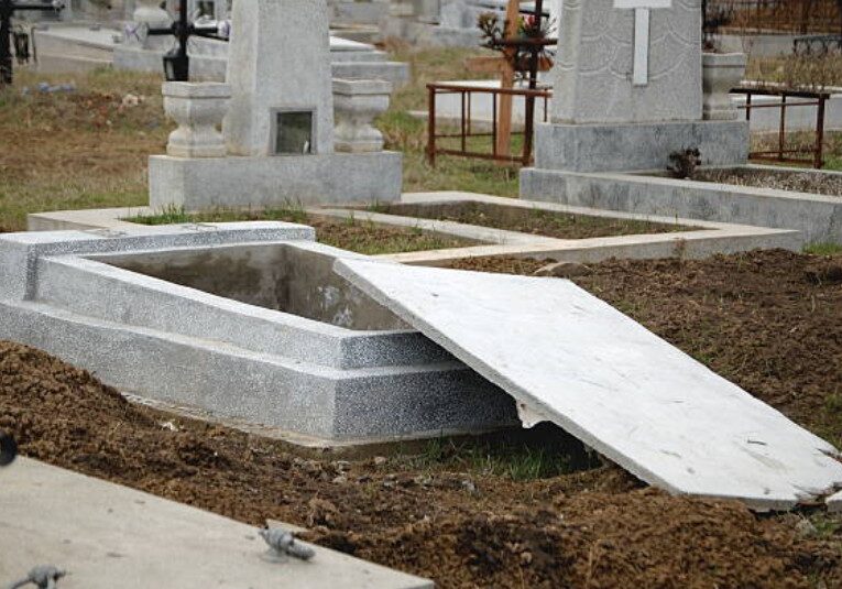 An stone grave casket with an open cover.