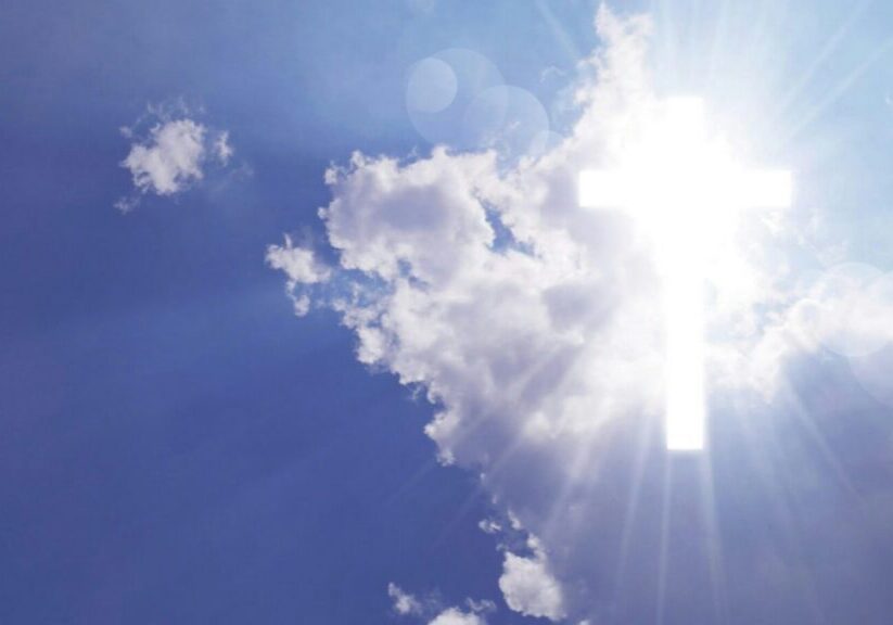 A bright shining cross breaking through the clouds